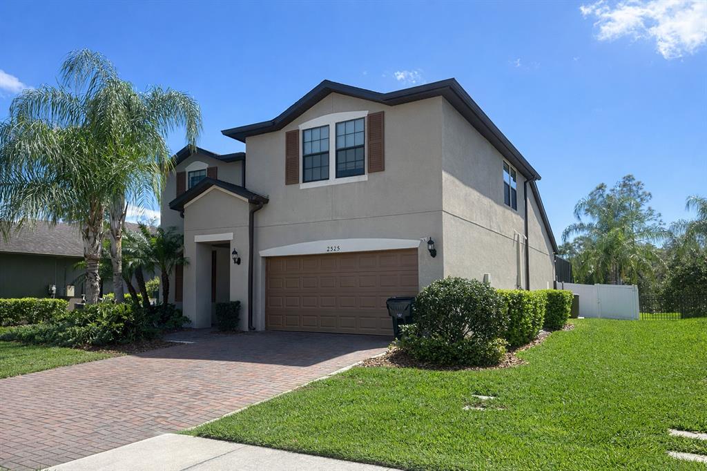 A two-story house with a beige stucco exterior, brown garage door, and a paved driveway — 2515 SHERMAN OAK DRIVE, NORTH PORT, FL
