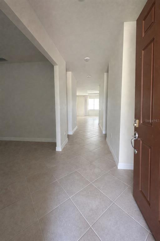 An entryway with tile flooring leads into a hallway with recessed lighting and white walls — 2515 SHERMAN OAK DRIVE, NORTH PORT, FL