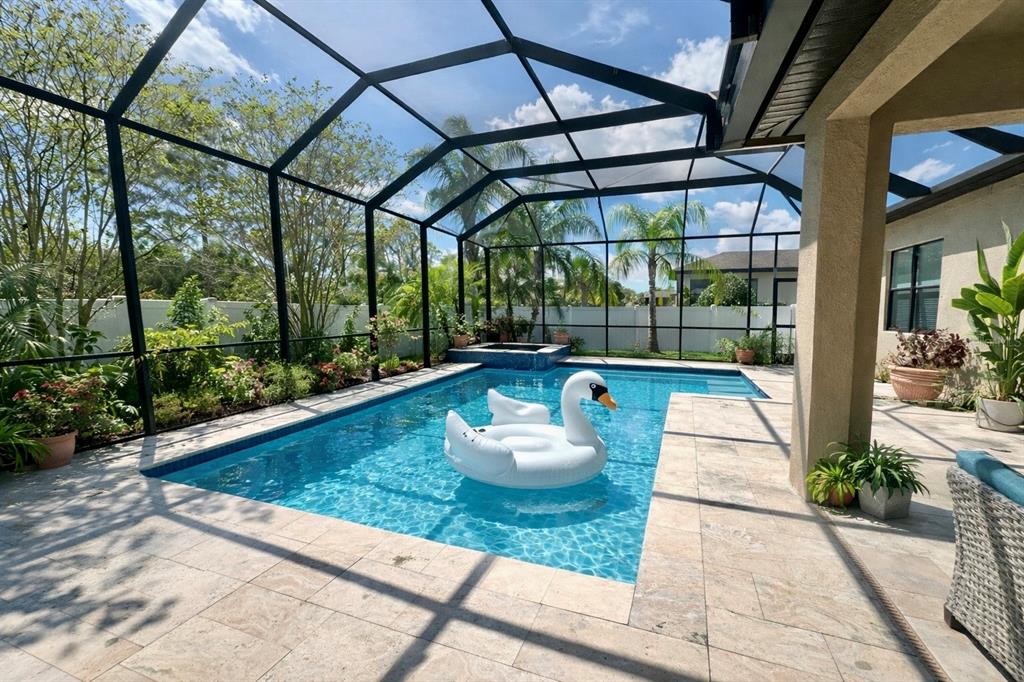 A screened-in swimming pool with a swan float and a hot tub on a patio — 2515 SHERMAN OAK DRIVE, NORTH PORT, FL