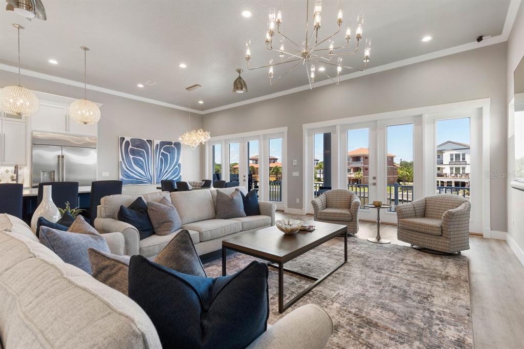A bright living room features a large sectional, two armchairs, and a modern chandelier — 18 SPINAKER CIRCLE, PALM COAST, FL