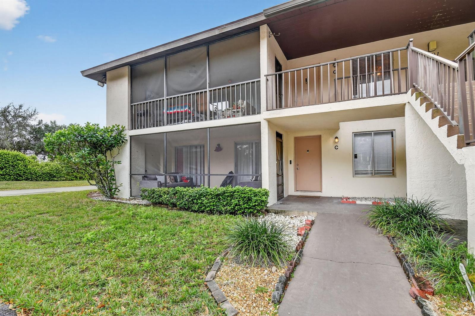 A two-story apartment building features a screened-in ground floor patio and an upper balcony — 4191 S 57th Avenue G Avenue, FL 33463, FL