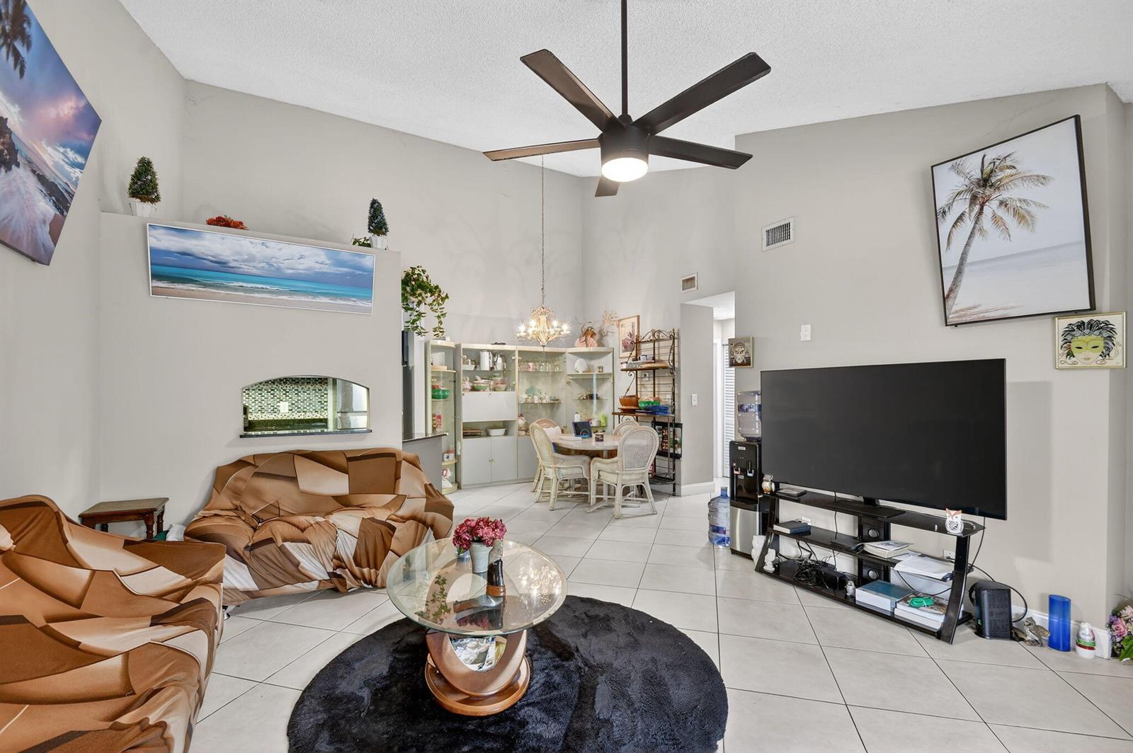 A living room with tile floors, a ceiling fan, and a dining area in the background — 4191 S 57th Avenue G Avenue, FL 33463, FL