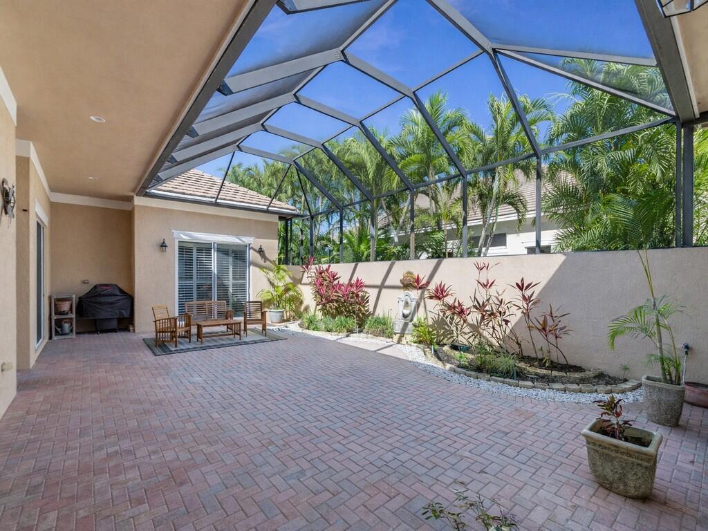 A single-story house with a tan exterior, a tiled roof, and a landscaped front yard — 1208 Riverwind Circle, Vero Beach FL 32967, VERO BEACH, FL