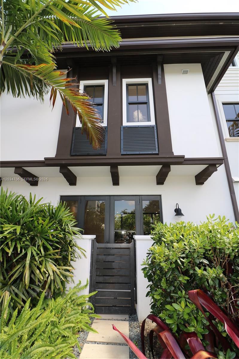 A two-story building exterior features white walls, dark brown trim, and a gated entrance — 7504 SW 100th St, Pinecrest FL 33156, PINECREST, FL