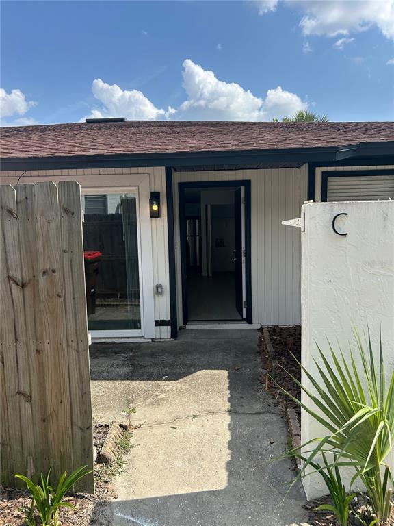 The exterior view shows a concrete walkway leading to an open doorway of a unit — 2955 SE 53RD COURT UNIT C, OCALA, FL