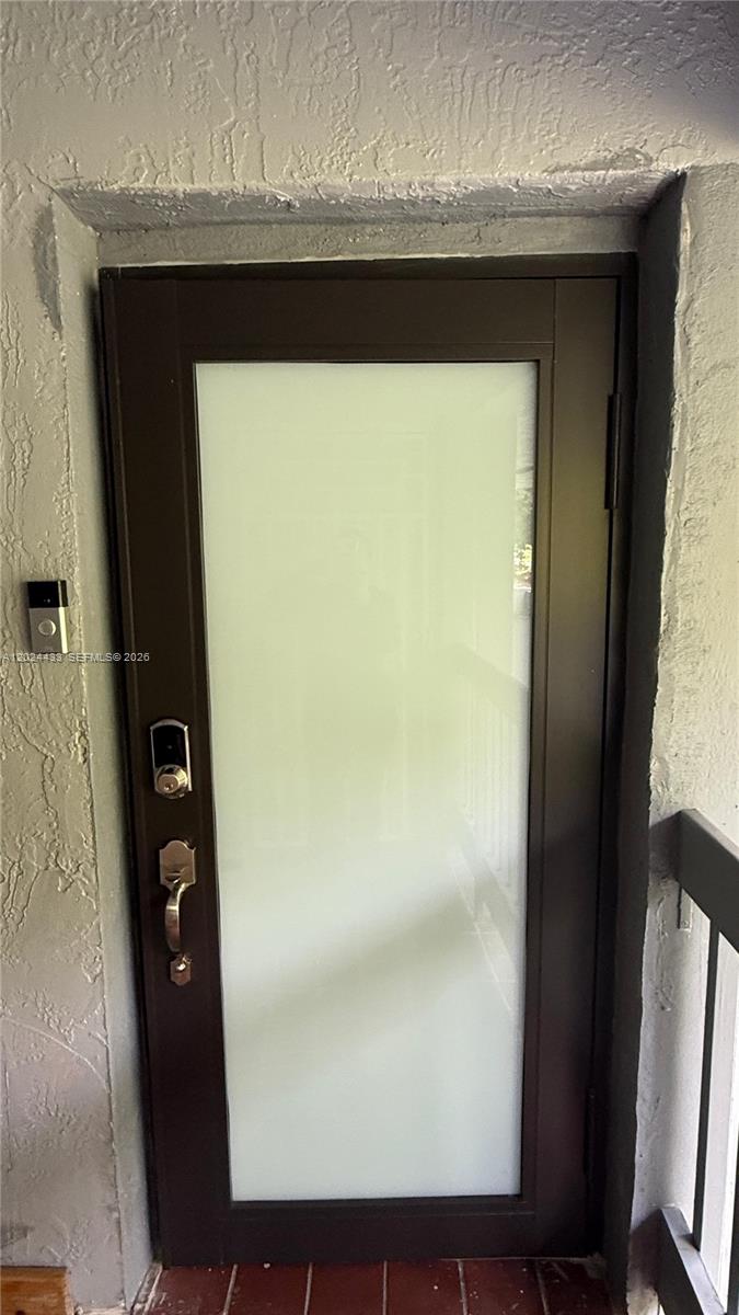 A dark-framed door with a large frosted glass panel features a smart lock and doorbell — 13675 SW 62nd St # 3, Miami FL 33183, MIAMI, FL