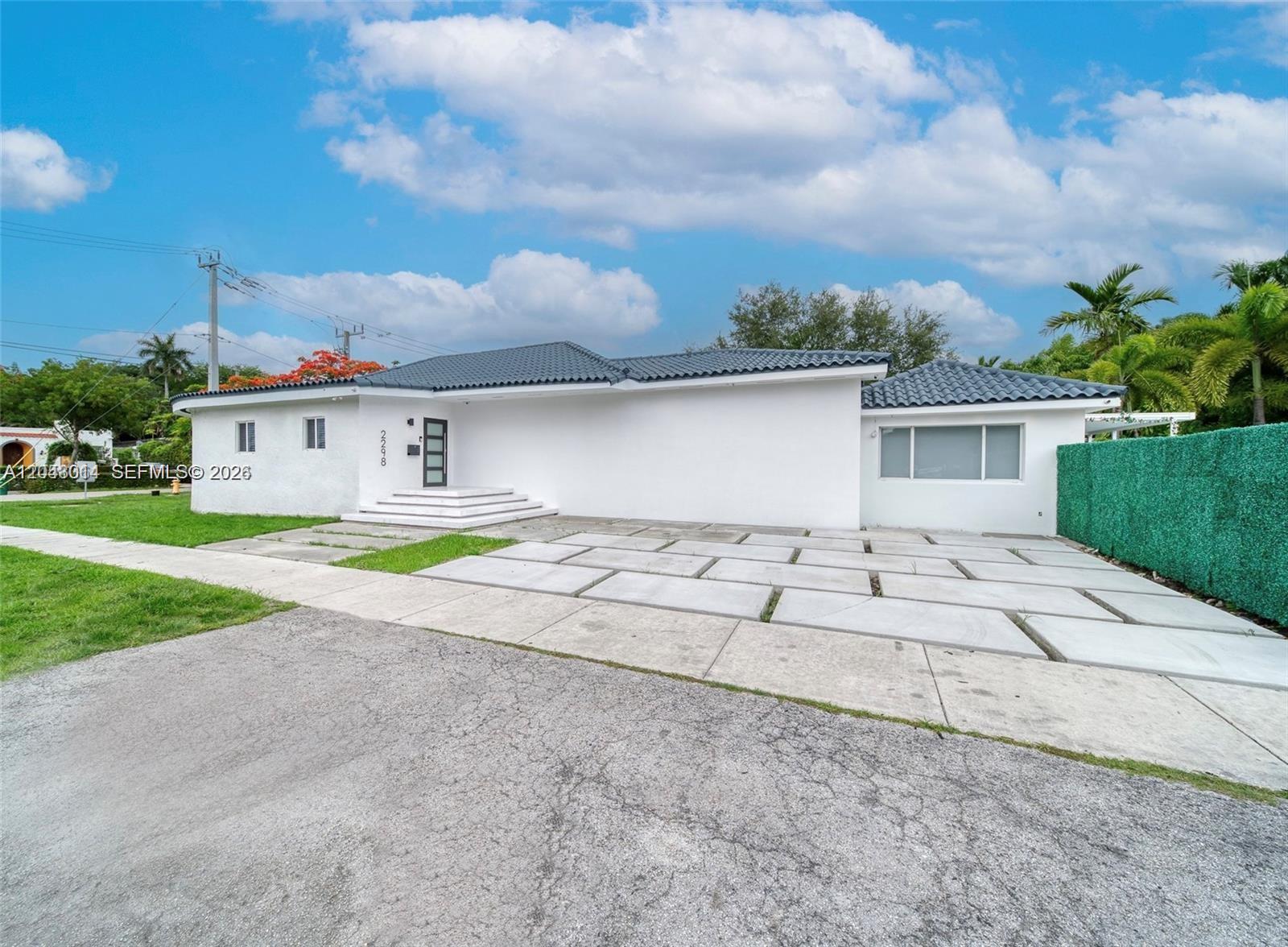 A white single-story house features a dark tiled roof and a concrete paver driveway — 2298 SW 16th Ave, Miami FL 33145, MIAMI, FL