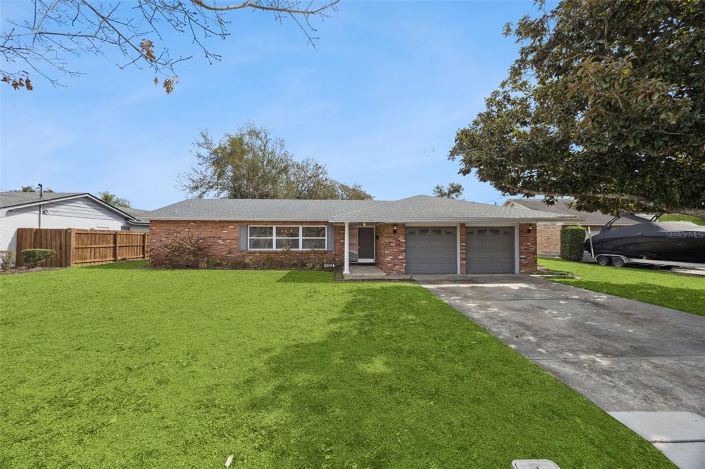 A single-story brick house features a two-car garage and a large front lawn — 2504 LAUDERDALE COURT, ORLANDO, FL