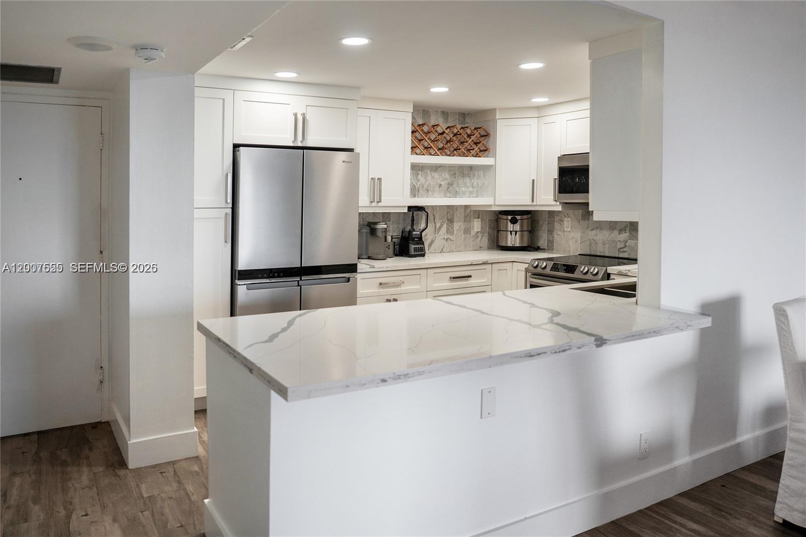 A modern kitchen features white cabinetry, stainless steel appliances, and a marble-patterned quartz countertop — 1600 S Ocean Dr # 17D, Hollywood FL 33019, HOLLYWOOD, FL