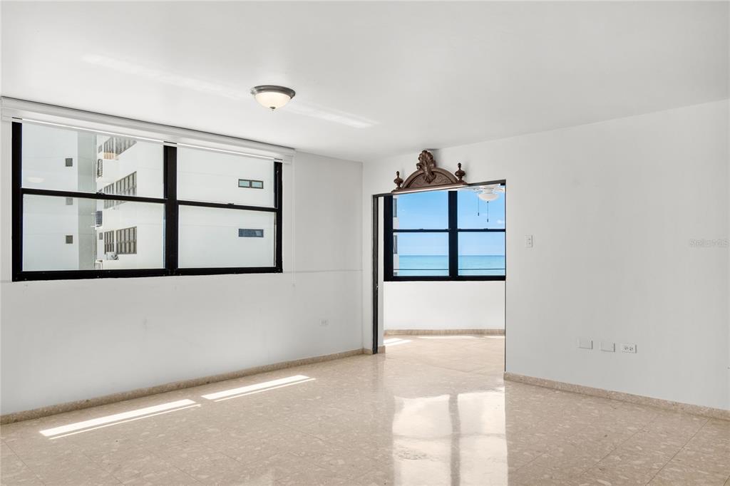 An empty room with light-colored tile floors, white walls, and windows overlooking the ocean — 2 WASHINGTON STREET UNIT 204, SAN JUAN, PR