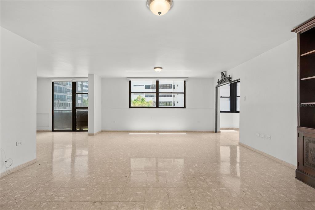 A spacious, empty room features light-colored tile flooring, white walls, and large windows — 2 WASHINGTON STREET UNIT 204, SAN JUAN, PR