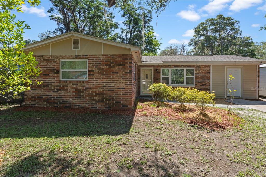 A single-story house features a brick exterior, tan siding, and a front-facing entrance — 1009 SE 20TH STREET, GAINESVILLE, FL