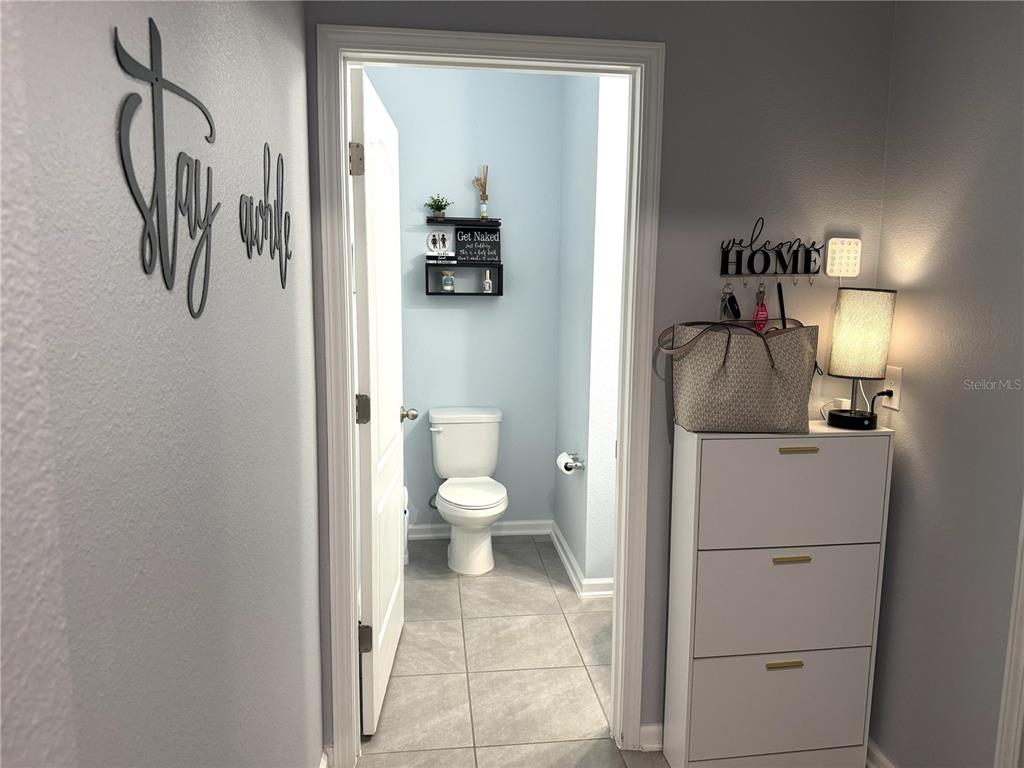 A view from a hallway into a small bathroom with light blue walls and tile — 103 REDBUD ROAD, PALM COAST, FL
