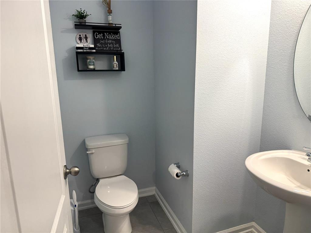 A half bathroom features light blue walls, a pedestal sink, and a toilet — 103 REDBUD ROAD, PALM COAST, FL