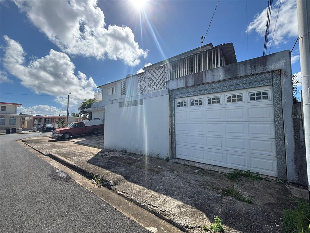 A white concrete house features a large garage door and an upper-level balcony with railings — 950(19AK) LINANCERO ST EXT COUNTRY CLUB DEVELOPMENT, SAN JUAN, PR