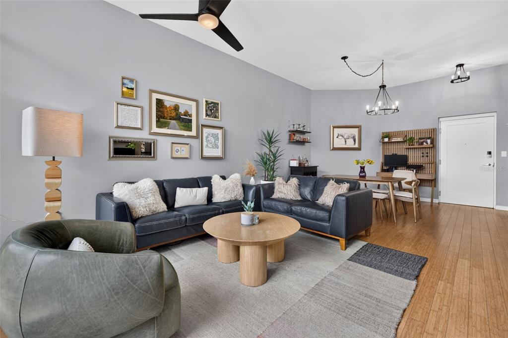 A living room features dark leather sofas, a round wooden coffee table, and hardwood floors — 400 4TH AVENUE S UNIT 408, ST PETERSBURG, FL