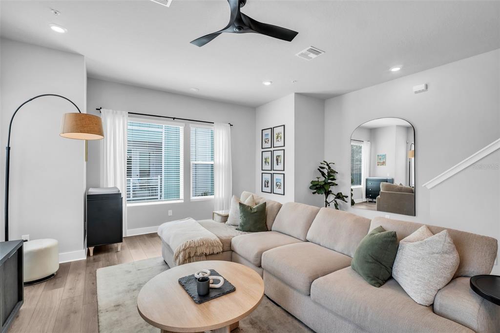 A living room features a beige sectional sofa, a round coffee table, and an arched mirror — 2851 1ST AVENUE S, ST PETERSBURG, FL