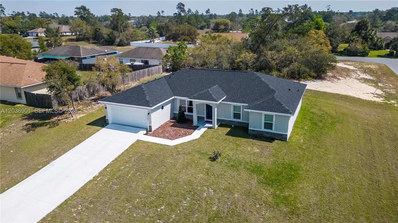An aerial view shows a single-story house with a dark roof, garage, and concrete driveway — 16365 SW 47 Terrace, Ocala FL 34473, OCALA, FL