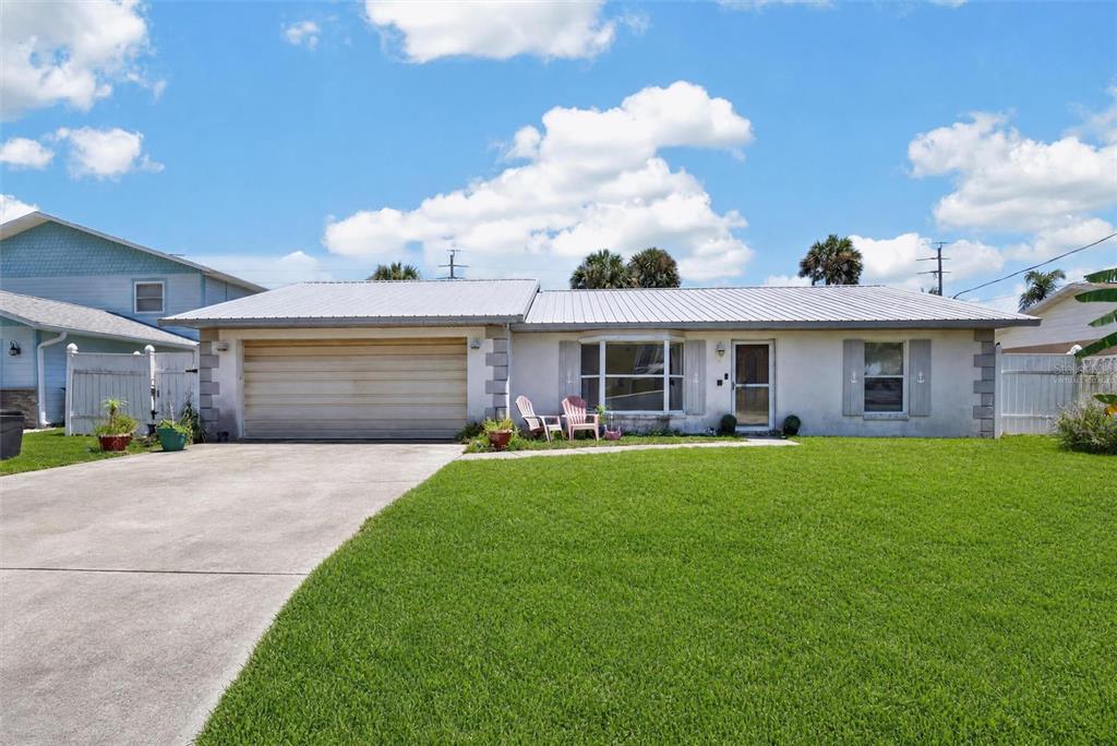 A single-story house with a white exterior, metal roof, and a two-car garage — 4211 CARDINAL BOULEVARD, PORT ORANGE, FL