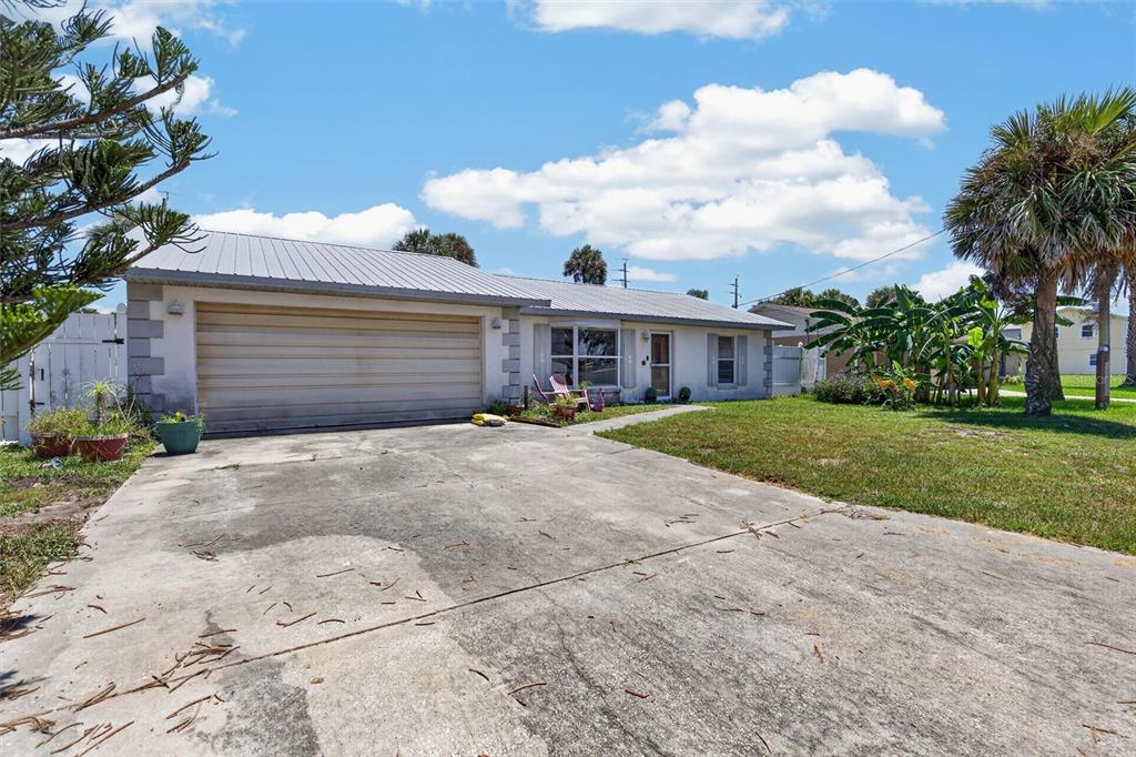A single-story house with a metal roof, a concrete driveway, and a large garage — 4211 CARDINAL BOULEVARD, PORT ORANGE, FL