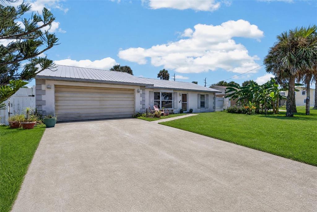 A single-story house with a metal roof, a concrete driveway, and a front lawn — 4211 CARDINAL BOULEVARD, PORT ORANGE, FL