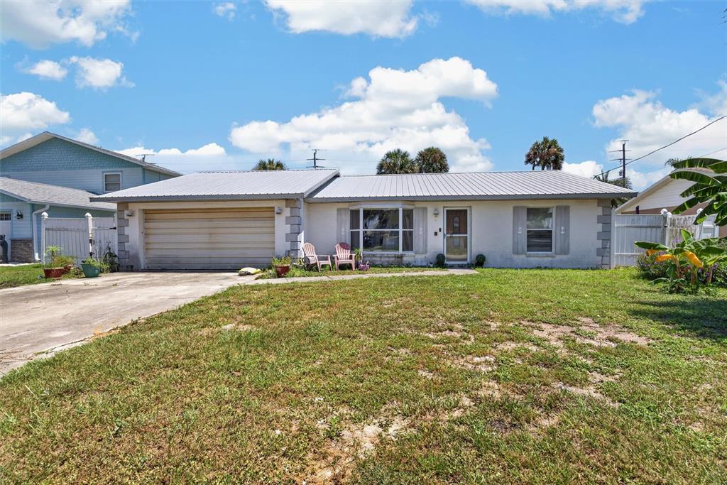 A single-story house with a metal roof, two-car garage, and a front lawn — 4211 CARDINAL BOULEVARD, PORT ORANGE, FL