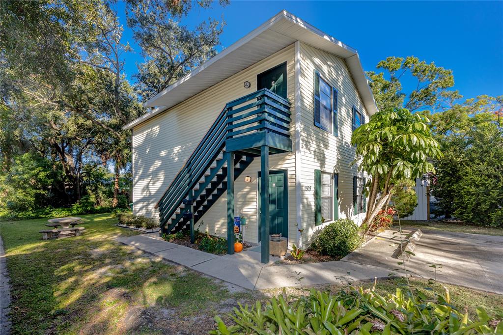 A two-story building with light siding, dark green doors, and an exterior staircase — 1303 S MOODY AVENUE, TAMPA, FL
