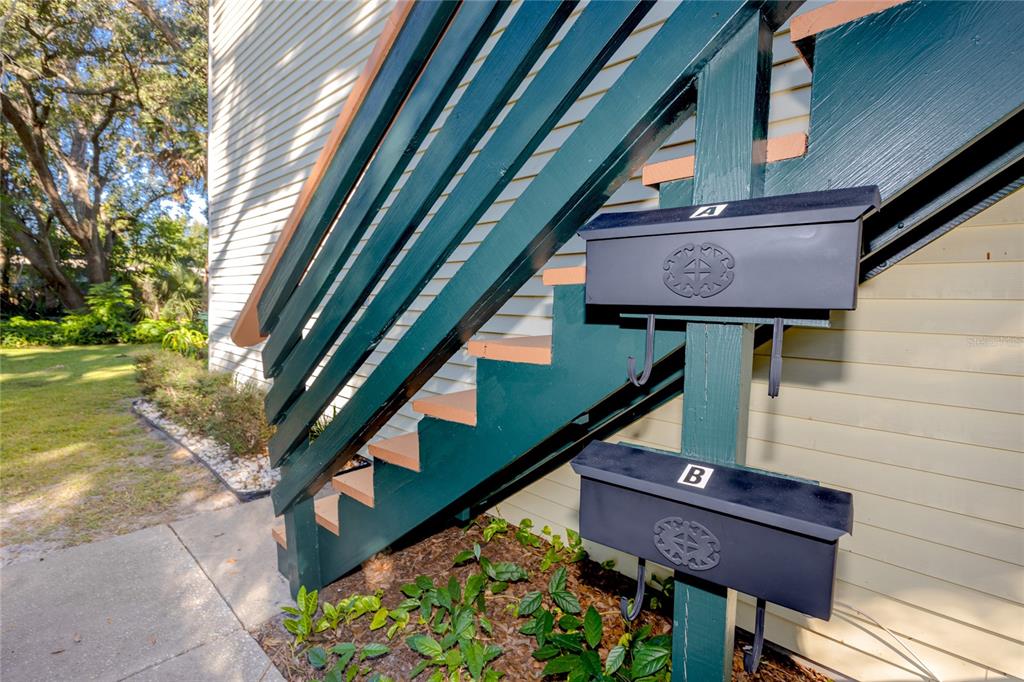 Two black mailboxes labeled A and B are mounted on a post beside outdoor stairs — 1303 S MOODY AVENUE, TAMPA, FL