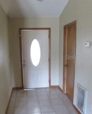 An entryway features a white front door with an oval window and a tiled floor — 824 BERRYHILL CIRCLE, FRUITLAND PARK, FL