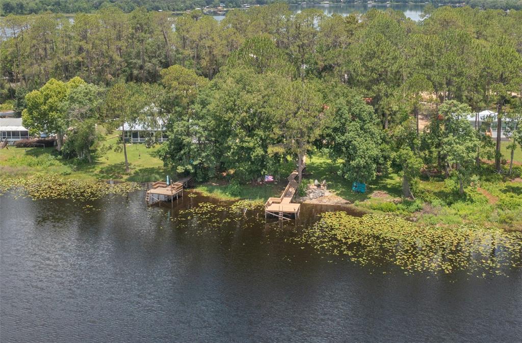 An aerial view shows a lakefront property with two wooden docks and a house — 303 RILEY LAKE DRIVE, HAWTHORNE, FL
