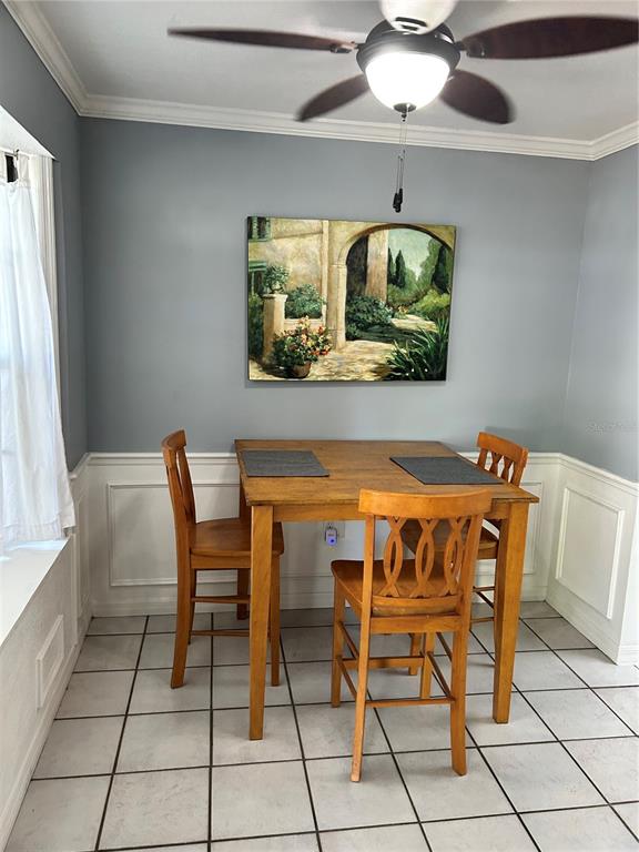 A dining area features a wooden table, three chairs, a ceiling fan, and wall art — 4543 SW 44TH LANE, GAINESVILLE, FL