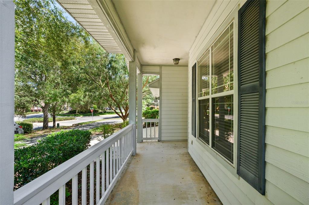 A covered front porch features a concrete floor, white railings, and a window with shutters — 7652 SW 85TH DRIVE, GAINESVILLE, FL
