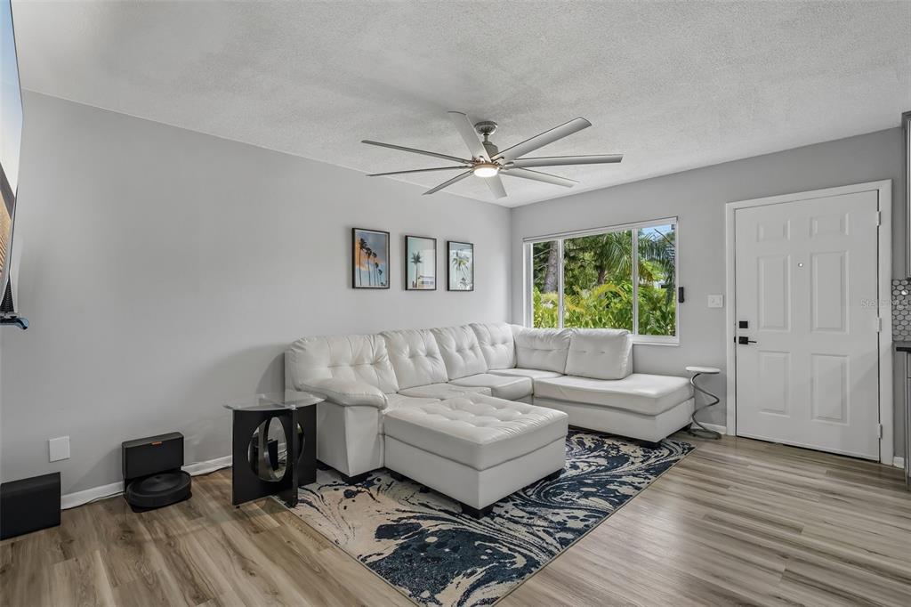 A living room features a white sectional sofa, a patterned rug, and a ceiling fan — 5043 14TH AVENUE N, ST PETERSBURG, FL