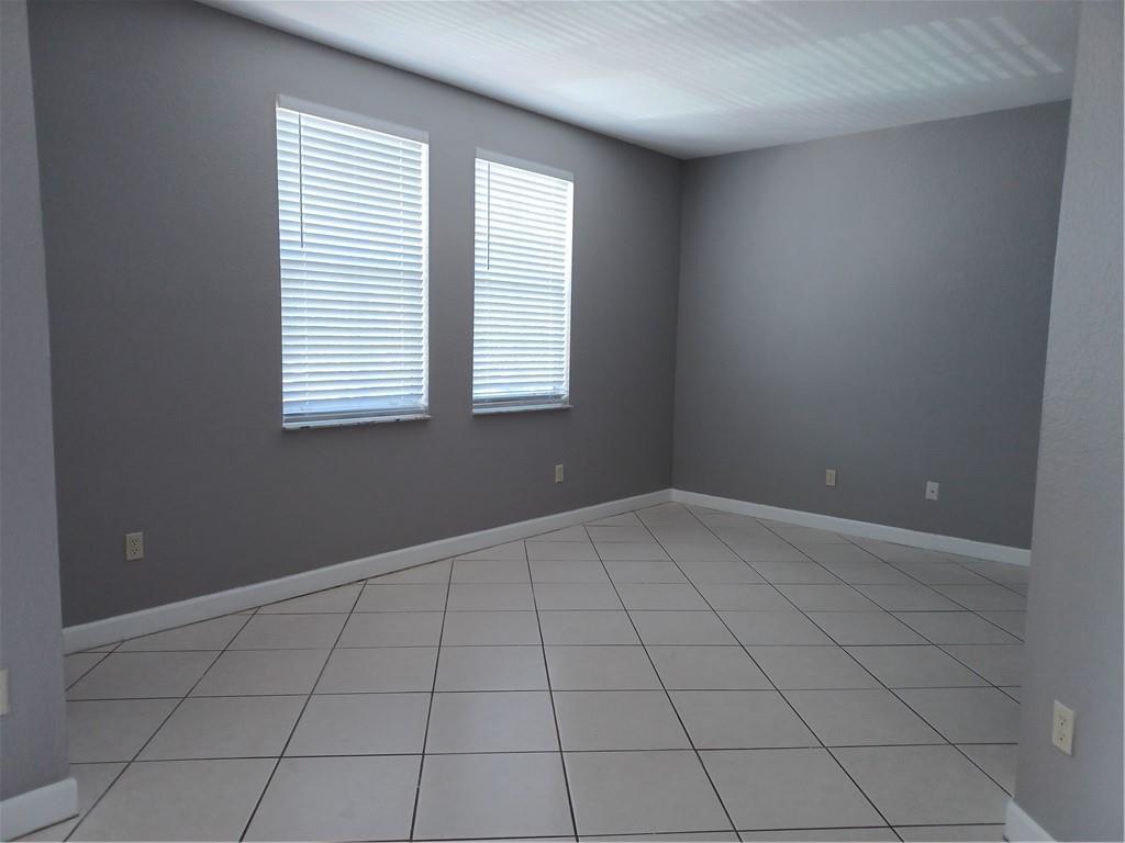 An empty room with gray walls, white trim, and light-colored square floor tiles — 4321 SW 160th Avenue # 203, Miramar FL 33027, MIRAMAR, FL