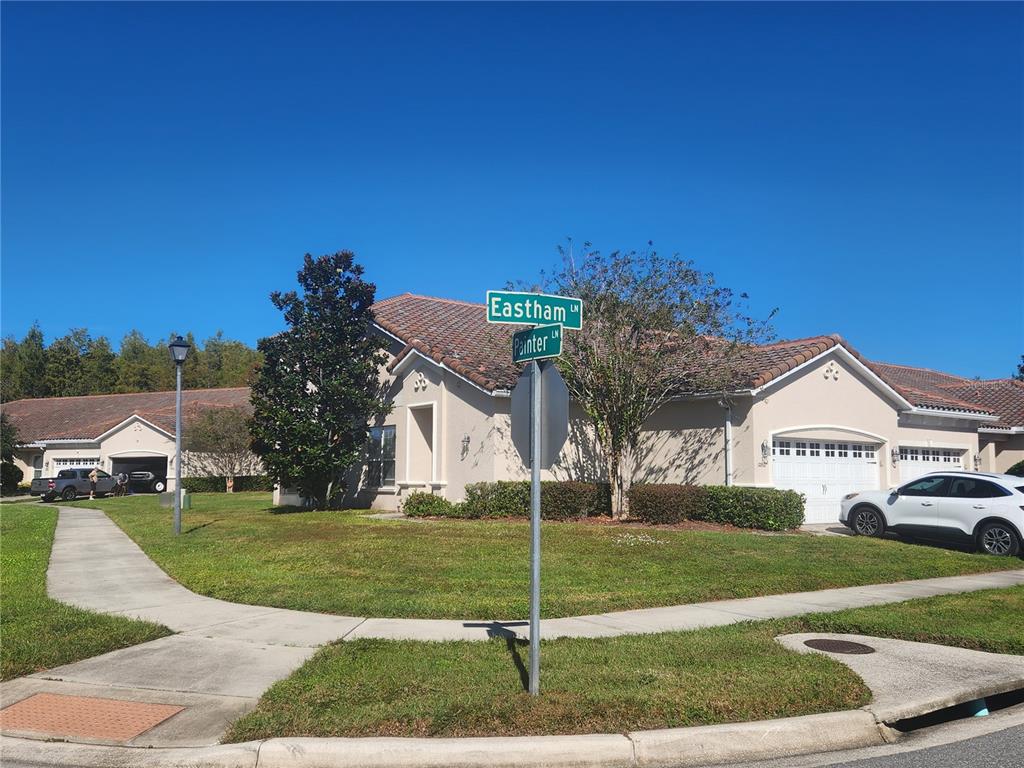 A single-story house with a tiled roof stands at the corner of two residential streets — 2852 EASTHAM LANE, KISSIMMEE, FL