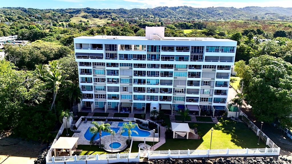 An aerial view of a multi-story apartment building with a swimming pool and landscaped grounds — 429 C. PORTO VECCHIO UNIT 401, RINCON, PR