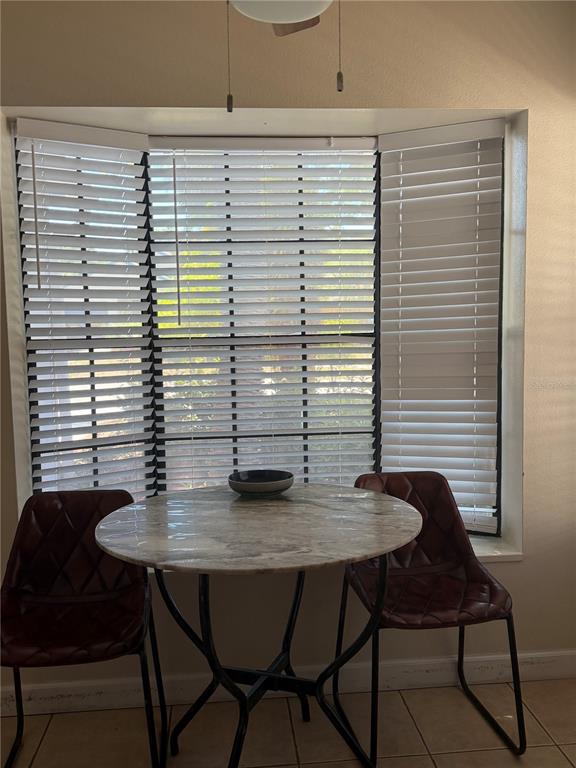A small round marble-topped table with two chairs sits in front of a bay window — 650 BELLINGHAM PLACE, PALM HARBOR, FL
