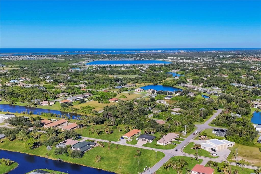 An aerial view shows a residential neighborhood with houses, green spaces, and several small lakes — 357 BOUNDARY BOULEVARD, ROTONDA WEST, FL