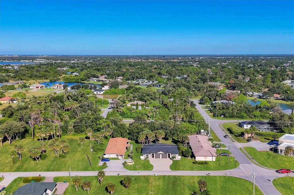 An aerial view shows a residential neighborhood with houses, green lawns, and scattered trees — 357 BOUNDARY BOULEVARD, ROTONDA WEST, FL