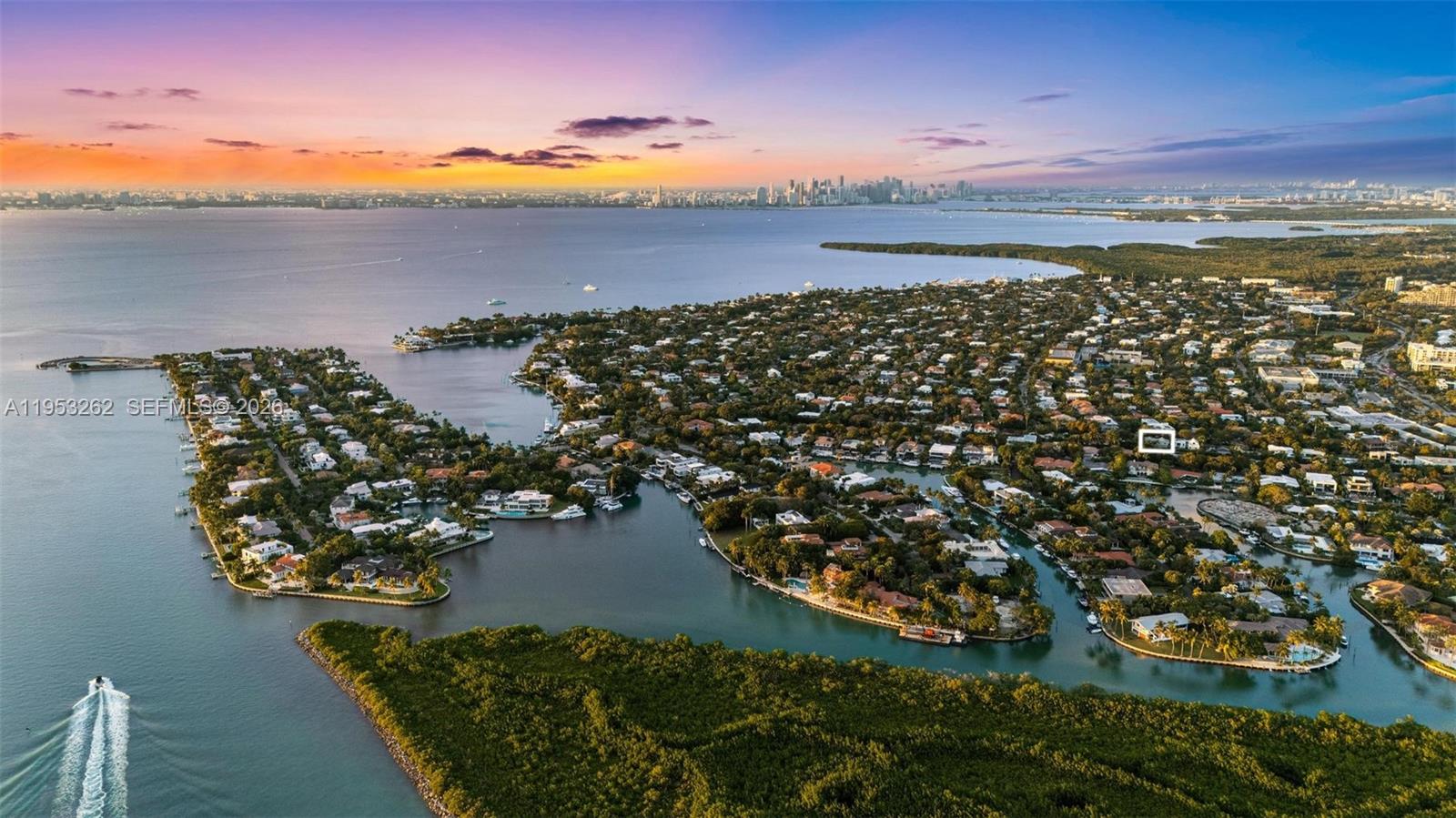 An aerial view of a coastal residential neighborhood with a sunset skyline in the distance — 164 W Mashta Dr, Key Biscayne FL 33149, KEY BISCAYNE, FL