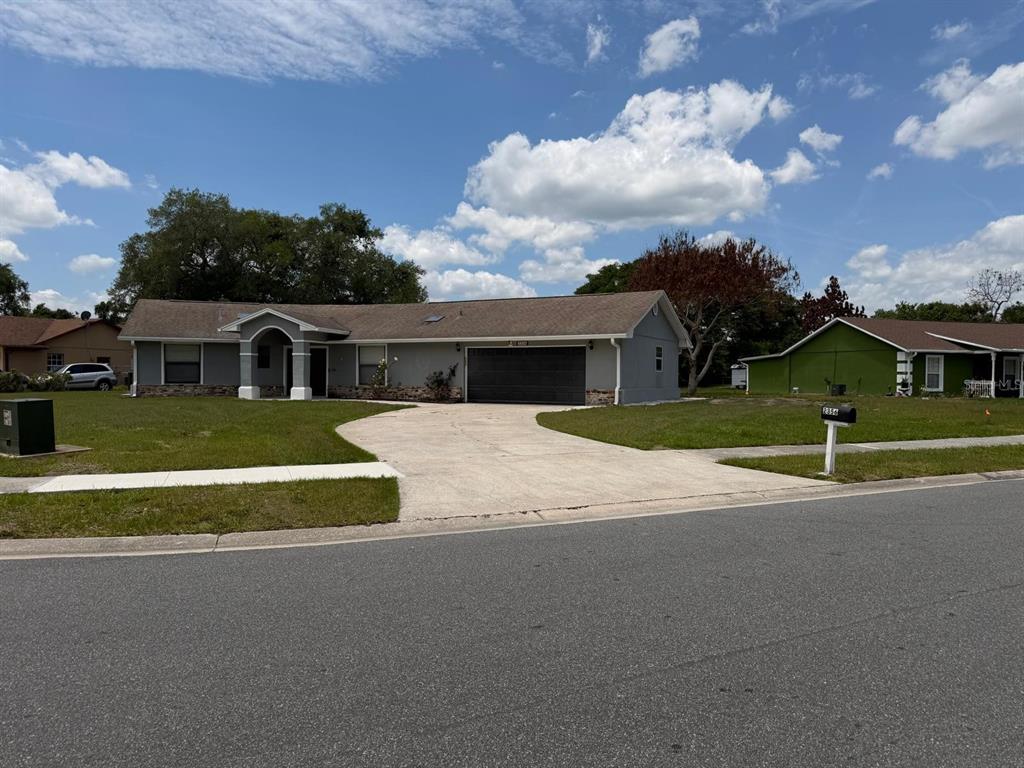 A single-story house with a gray exterior, a two-car garage, and a concrete driveway — 2356 ROYALE OAKS BOULEVARD, KISSIMMEE, FL