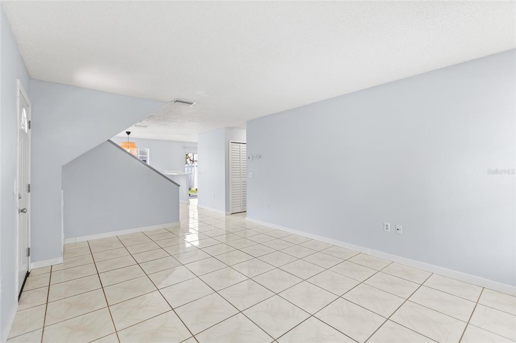 A living room features a beige sofa, two blue armchairs, and a patterned area rug — 7608 WILLOW PARK DRIVE, TEMPLE TERRACE, FL