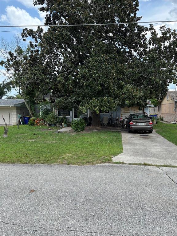 A large tree shades the front yard and driveway of a single-story house — 110 E TURGOT AVENUE, EDGEWATER, FL