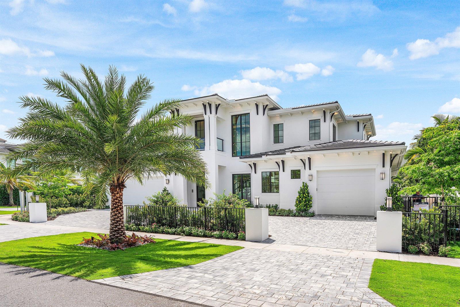 A two-story white modern house features a paved driveway, a palm tree, and black trim — 201 NE 4th Avenue, Boca Raton FL 33432, BOCA RATON, FL