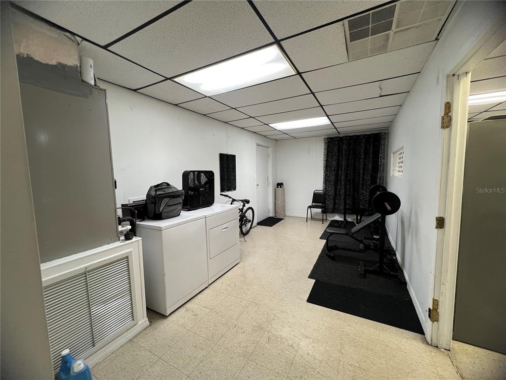 A utility room features a washer, dryer, drop ceiling, and a home gym area — 3887 E US HIGHWAY 90, LAKE CITY, FL