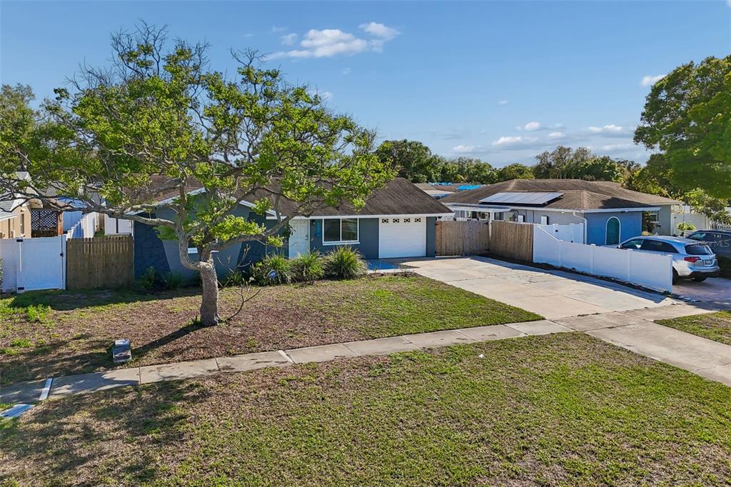 A single-story house with a gray exterior, a white garage door, and a front yard — 6882 62ND AVENUE N, PINELLAS PARK, FL