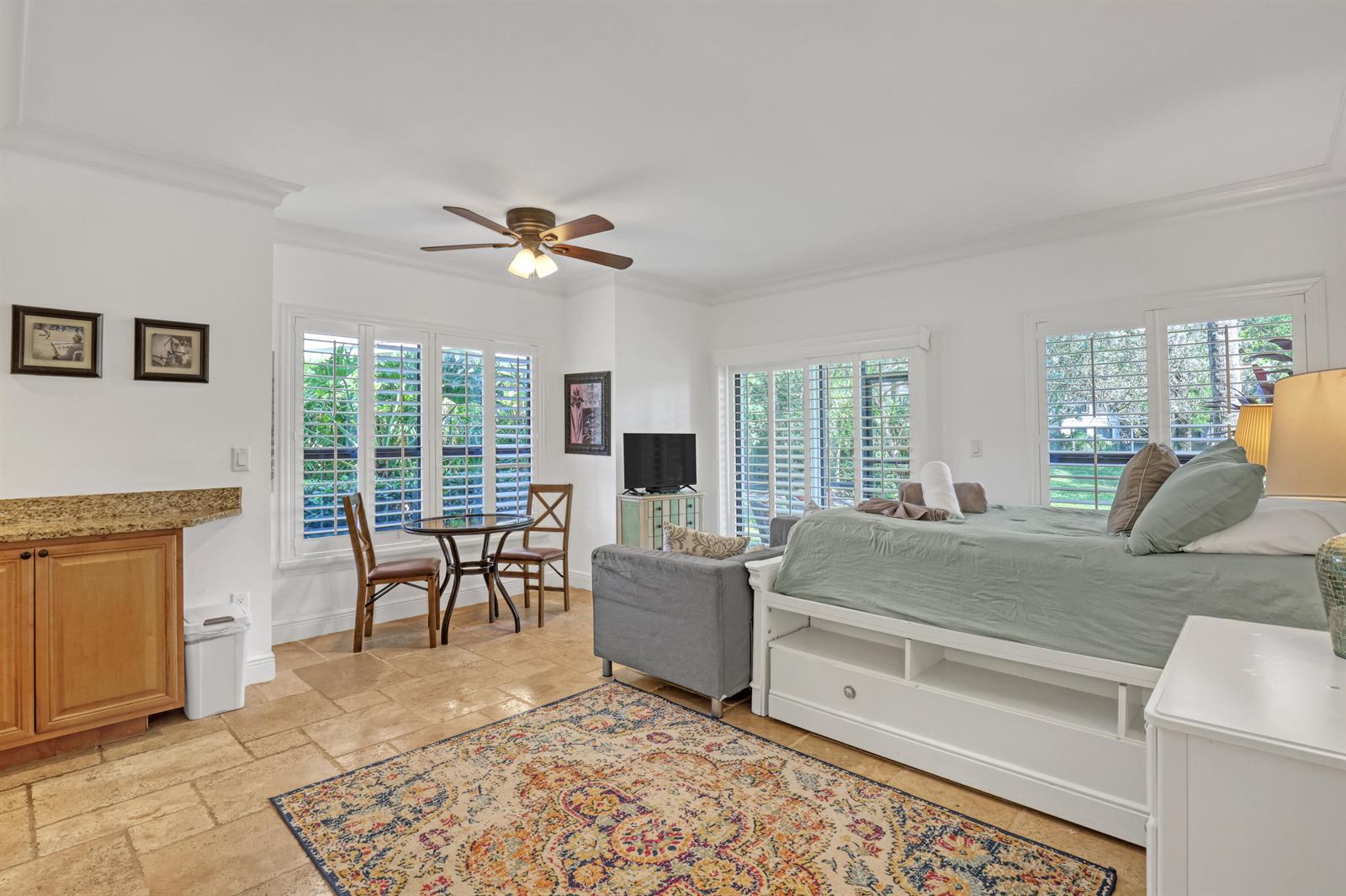 A bedroom with a bed, a small dining table, and a kitchenette on tile flooring — 11863 Wimbledon Circle # 408, Wellington FL 33414, WELLINGTON, FL