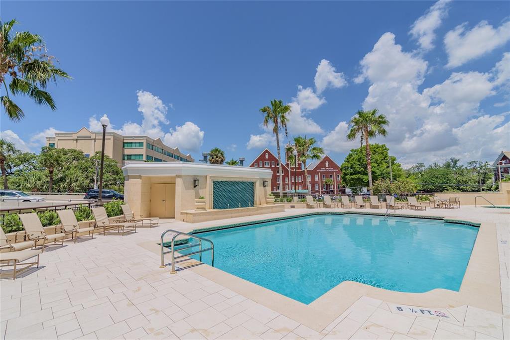 An outdoor swimming pool with a fountain feature is surrounded by lounge chairs and palm trees — 345 BAYSHORE BOULEVARD UNIT 1710, TAMPA, FL