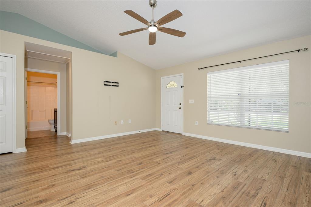 A living room with light-colored walls, wood-look flooring, a ceiling fan, and a window — 1491 16TH STREET, ORANGE CITY, FL