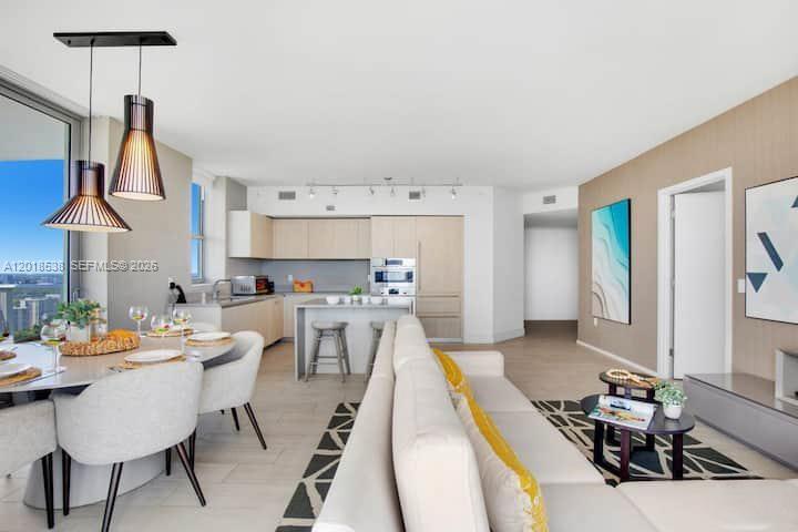 An open-concept living and dining area with a modern kitchen and floor-to-ceiling windows — 4010 S Ocean Dr # R2708, Hollywood FL 33019, HOLLYWOOD, FL